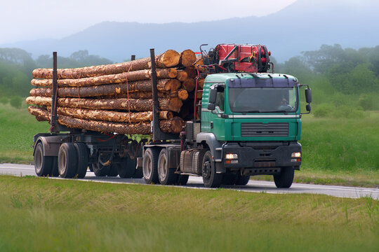 Heavy vehicle hauling wood through countryside