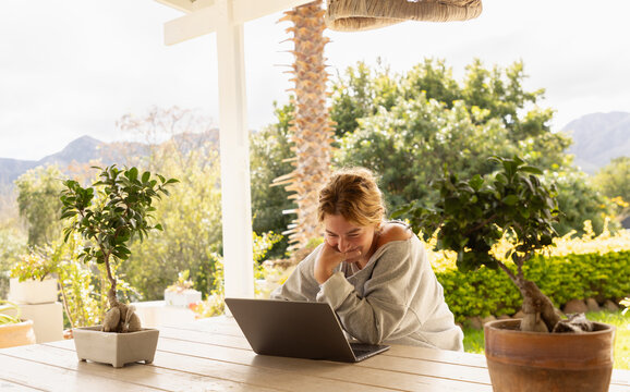 young woman using laptop computer on outdoor patio