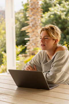 young woman using laptop computer on outdoor patio