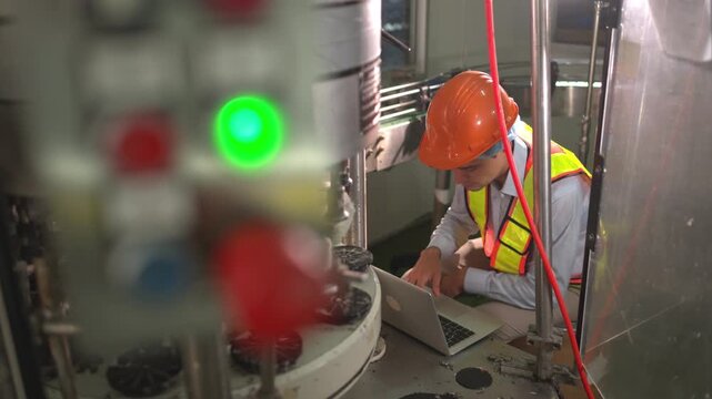 Engineer inspecting machinery with laptop in beverage production process