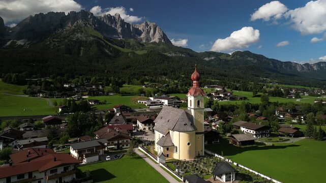 Holy Cross Parish in Going am Wilder Kaiser, Austria - Orbiting Move Aerial Footage