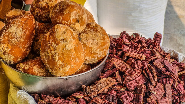 Close-up of natural jaggery blocks beside dried shikakai (Acacia concinna) pods, known as "fruit for hair," a traditional Ayurvedic ingredient used for natural hair cleansing and care