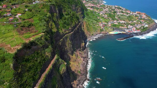Ponta Delgada Madeira Portugal Aerial Drone Flight Along Old Coastal Cliff Road ER101 Toward Scenic Village Peninsula Ocean Surge Waves Coastline Atlantic Travel Video 4K UHD