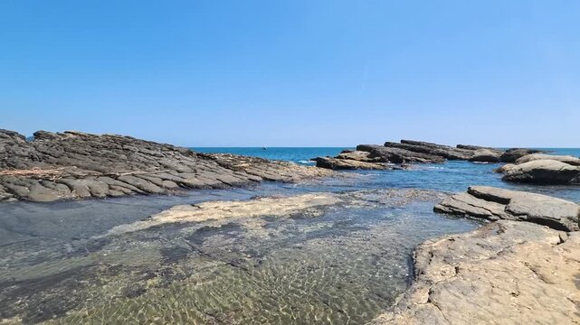 Shallow Crystal Clear Tide Pool Surrounded By Layered Sedimentary Coastal Rock Formations, 4K b-roll