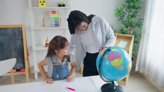 African tutor use educational globe to help a child learn about the world. 