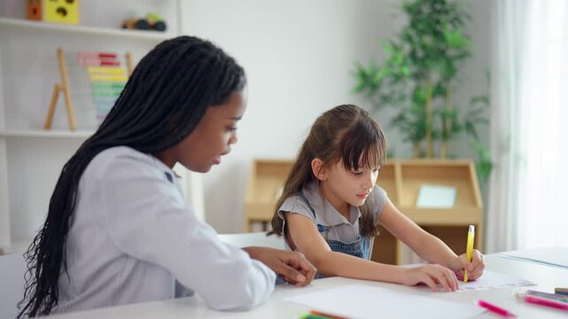 African woman tutor guide young child through learning activities on table. 