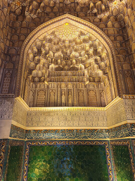 Muqarnas niche and green hexagonal tiles inside Shah-i-Zinda necropolis in Samarkand. Intricate Islamic interior decoration with calligraphy and geometric patterns ideal for travel and cultural.