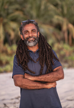Happy man with dreadlocks and beard on beach