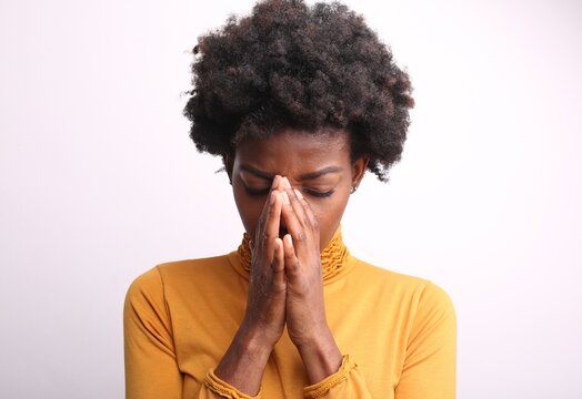 Young black woman praying with her eyes closed