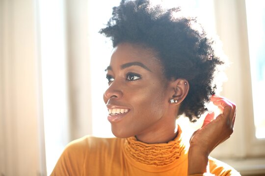 Smiling Black woman with natural hair in sunlight