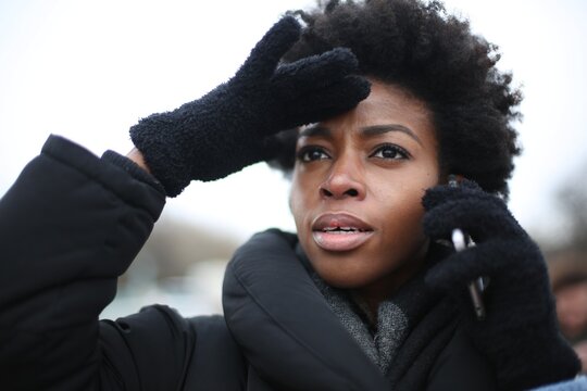 Concerned woman on a phone call shields her eyes