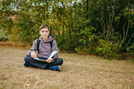 Boy checking homework in a notebook before returning to school