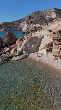 Agios Ioannis Beach in Milos Greece showcases crystal-clear waters and stunning rock formations. Enjoy the serenity and natural beauty, perfect for a relaxing getaway on a sunny day