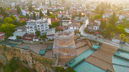 Fototapeta premium Antalya, Turkey. Aerial drone view of Hidirlik Tower integrated with Kaleici Old Town architecture and narrow streets in warm morning light.. Aerial View