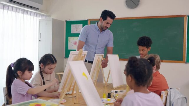 Caucasian male teacher teaching art lesson to children in classroom. 