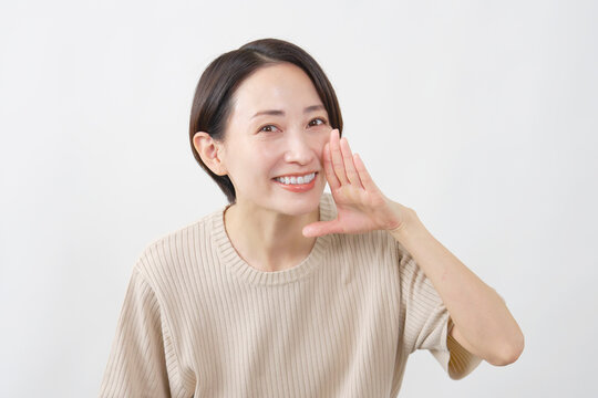 口元に手を添えて呼びかける女性　白背景