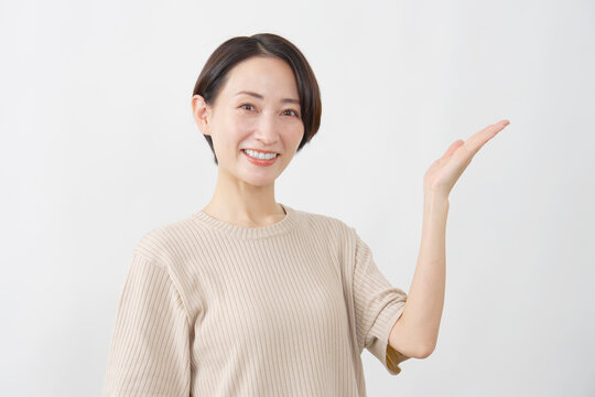 手のひらで指し示し案内する女性　白背景