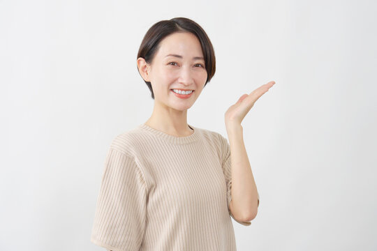 手のひらで指し示す笑顔の女性　白背景
