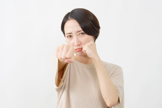 拳を構えて怒る女性　ミドルエイジ　白背景