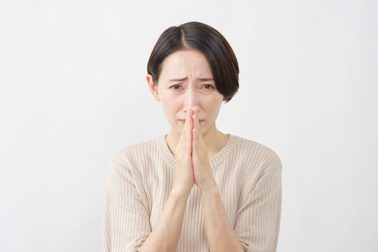 手を合わせて懇願する女性　白背景
