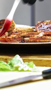Hands of chief on commercial kitchen serves fried bread