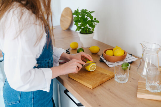 Person prepares fresh lemonade ingredients on a kitchen counter
