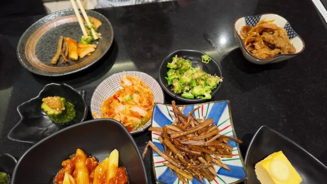 Person Eating Assorted Asian Side Dishes with Chopsticks in Bangkok