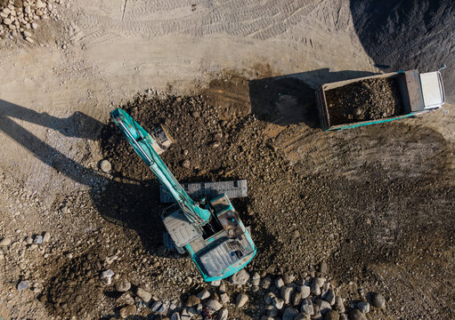 Kobelco Excavator and Dump Truck Working Together in Rock Quarry Mining Operation on July 21, 2026 in Banyumas, Central Java, Indonesia.