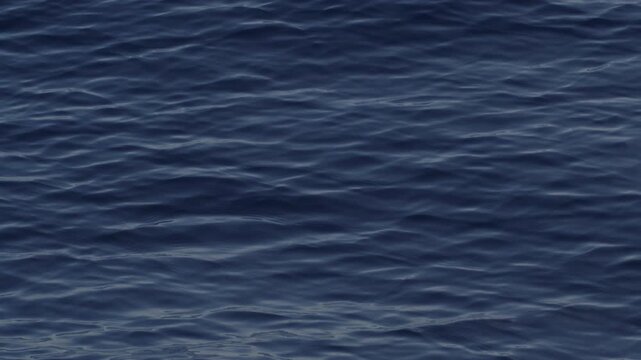 Sea surface with blinking stars and flares as seen from the moving sailing boat