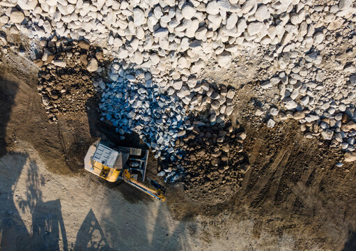 Aerial Scenery of Excavator Operating in Rock Quarry Mine with Gravel and Boulder Extraction, Construction and mining site view from above 