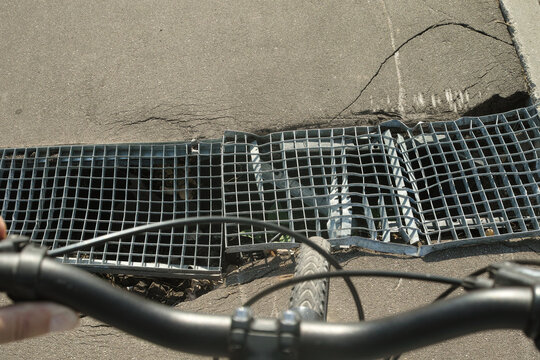 damaged asphalt and drainage grill