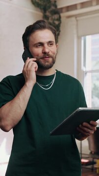 Barber, tablet and happy man with phone call for online booking, appointment or schedule in salon. Male person, stylist or checking list with technology or smartphone for customer service or session