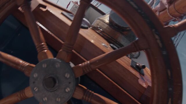 Expeditional sailing vessel moves in the open ocean. Camera spins, rotates and reveals the helm