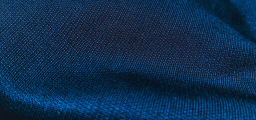 Dark blue fabric texture with soft wavy folds and dim lighting, creating an elegant and calm abstract backdrop © wiki