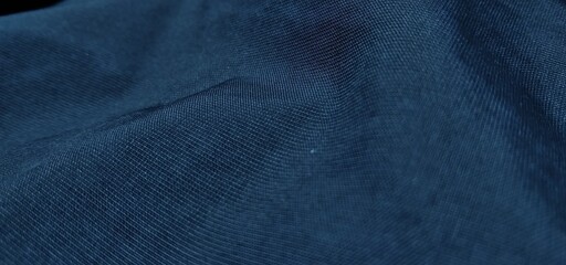 Dark blue fabric texture with soft wavy folds and dim lighting, creating an elegant and calm abstract backdrop © wiki