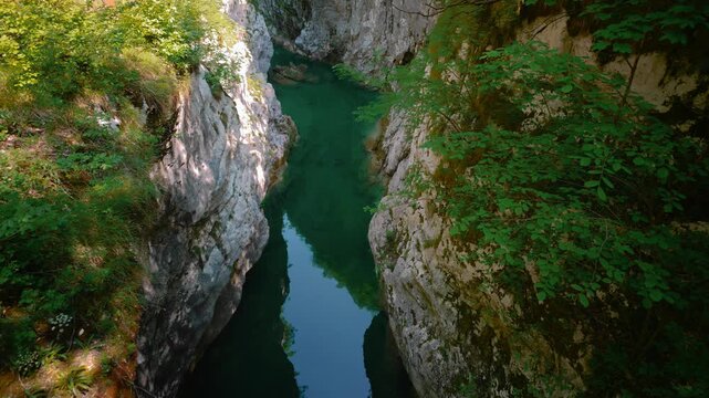 Sentiero del Dint view of a deep mountain canyon with bright emerald water and rugged limestone cliffs