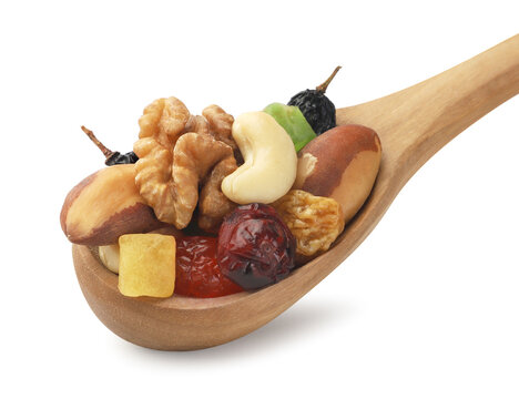 Mix of dried fruits and nuts in a wooden spoon on a white background. Isolated.