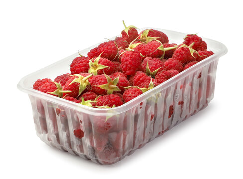 Ripe raspberries in a plastic container close-up on a white. Isolated