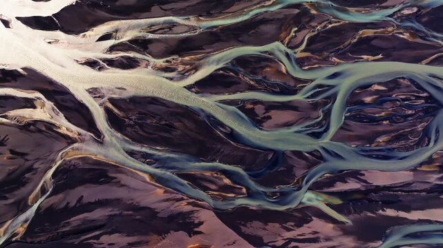 Abstract Veins of Glacial Meltwater Flowing Over Black Volcanic Sand