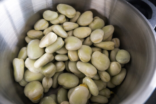 Broad beans cooking in a pot.
