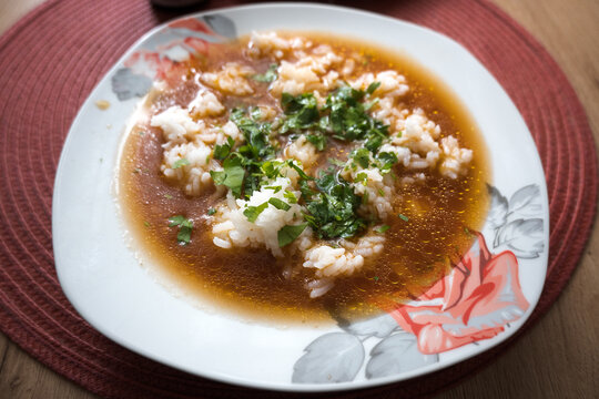 A plate of tomato soup with rice.
