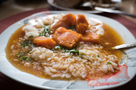 A plate of tomato soup with rice.
