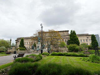 Obraz premium Historic neoclassical St Georges Hall civic building and statue in a park on an overcast day at Liverpool, UK