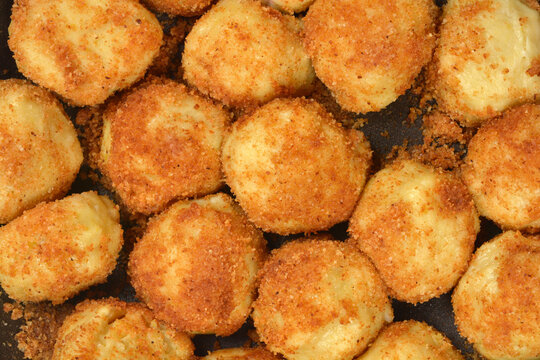 A macro shot of traditional sweet potato dumplings coated in golden fried breadcrumbs known as knedle in central and eastern Europe.