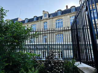 Obraz premium Historic Paris, France Luxembourg Palace building with wrought iron fence and garden framing classical stone facade under clear blue sky