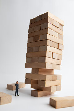 Precarious wooden blocks and miniature businessmen
