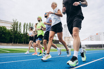 Fototapeta premium Group of runners jogging together on outdoor running track