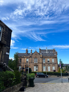 Residential streets in central Edinburgh with parked cars and traditional stone apartment buildings, urban real estate, historic city architecture and everyday