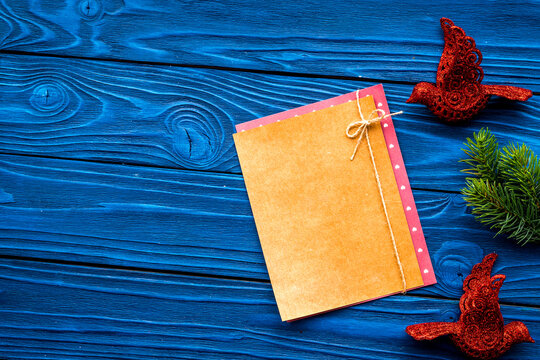 new year 2018 greeting with spruce branches and decorations with blank paper on blue wooden background top veiw space for text