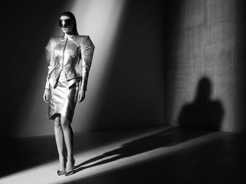 Fashion portrait of a futuristic woman in metallic clothing and oversized sunglasses